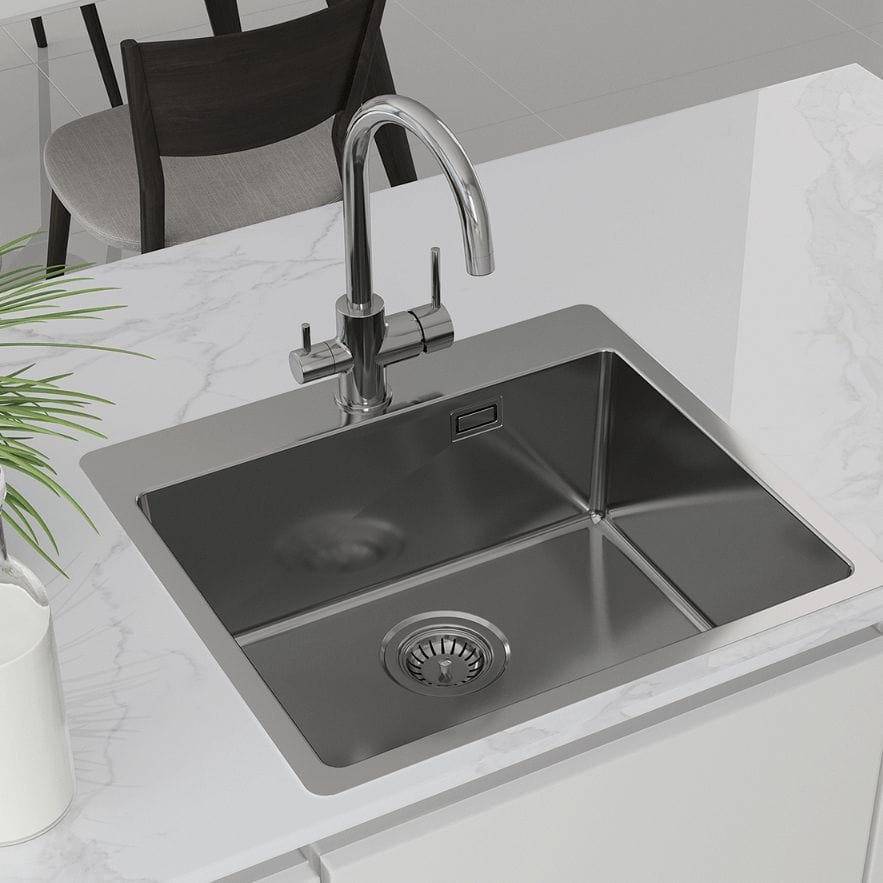 Stainless steel kitchen sink with modern faucet on white marble countertop, highlighting durable and hygienic material, perfect for contemporary kitchens, from filterplace.eu.